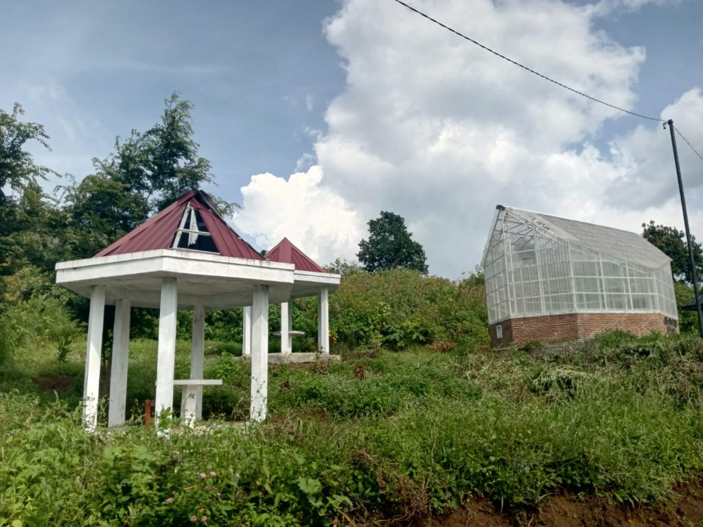 Gazebo yang rusak, dan rumah kaca yang kosong.
